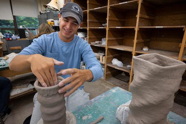 student working on ceramics vase 